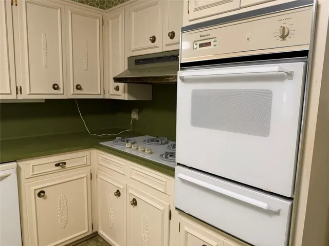 a kitchen with white cabinets and white appliances