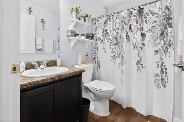 a bathroom with a granite countertop sink and a toilet