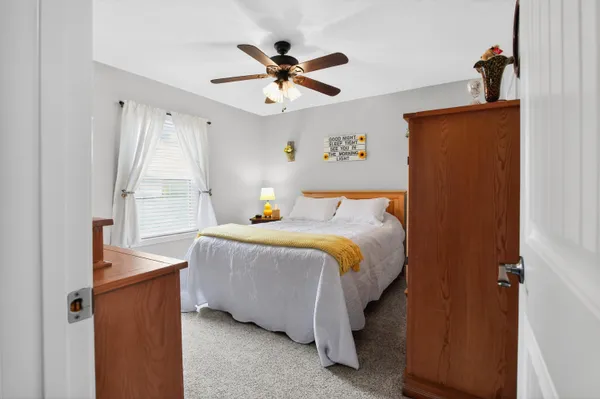 a bedroom with a bed and a ceiling fan