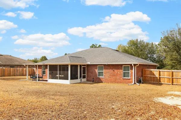 a view of a house with table and chairs in patio