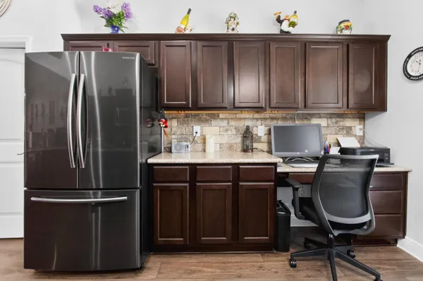 a kitchen with granite countertop a refrigerator and a chair