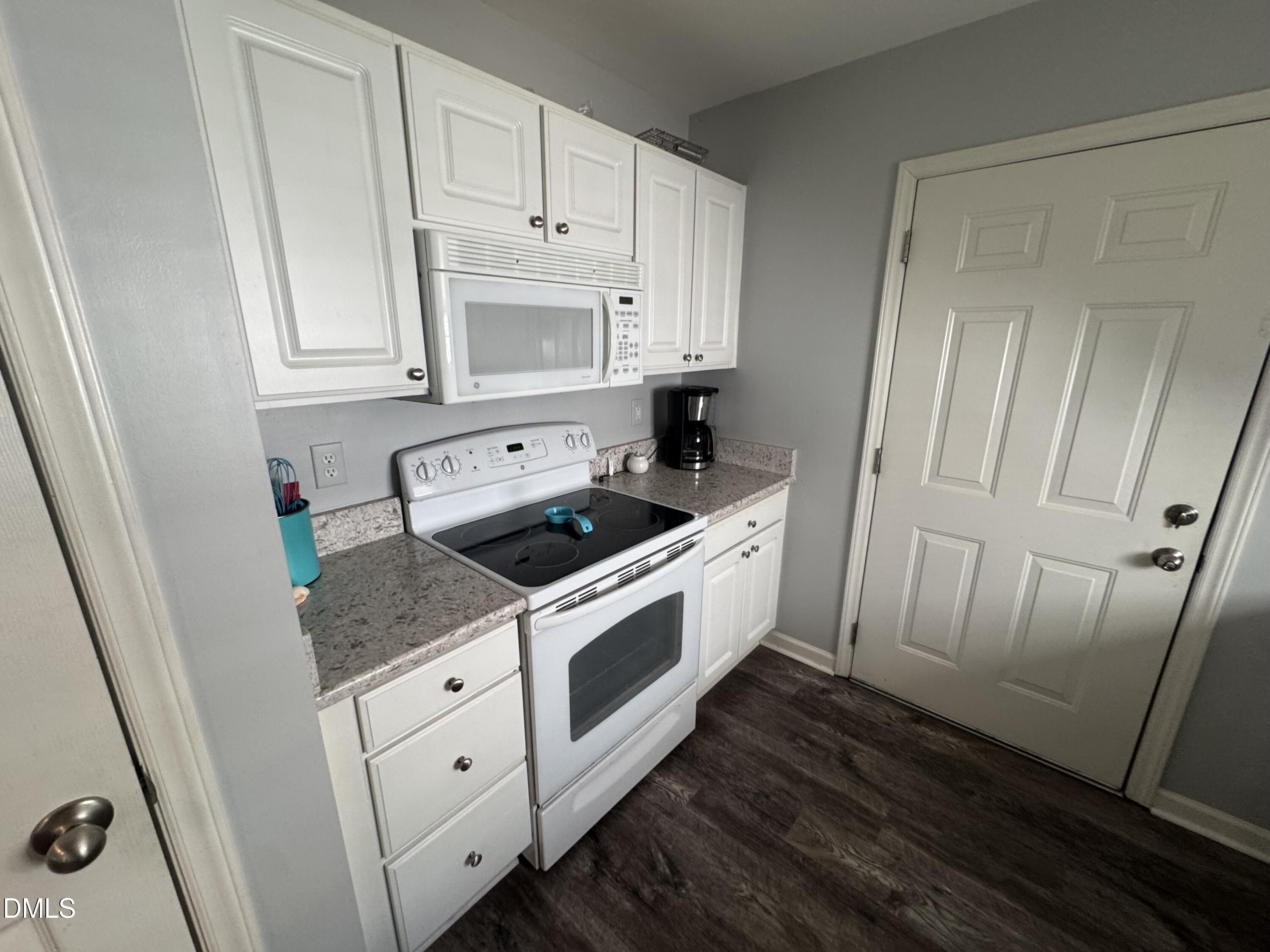 11351 Clubhaven Place, Unit 100 Raleigh, NC 27617 - Photo 10 of 29 a kitchen with white cabinets and white appliances