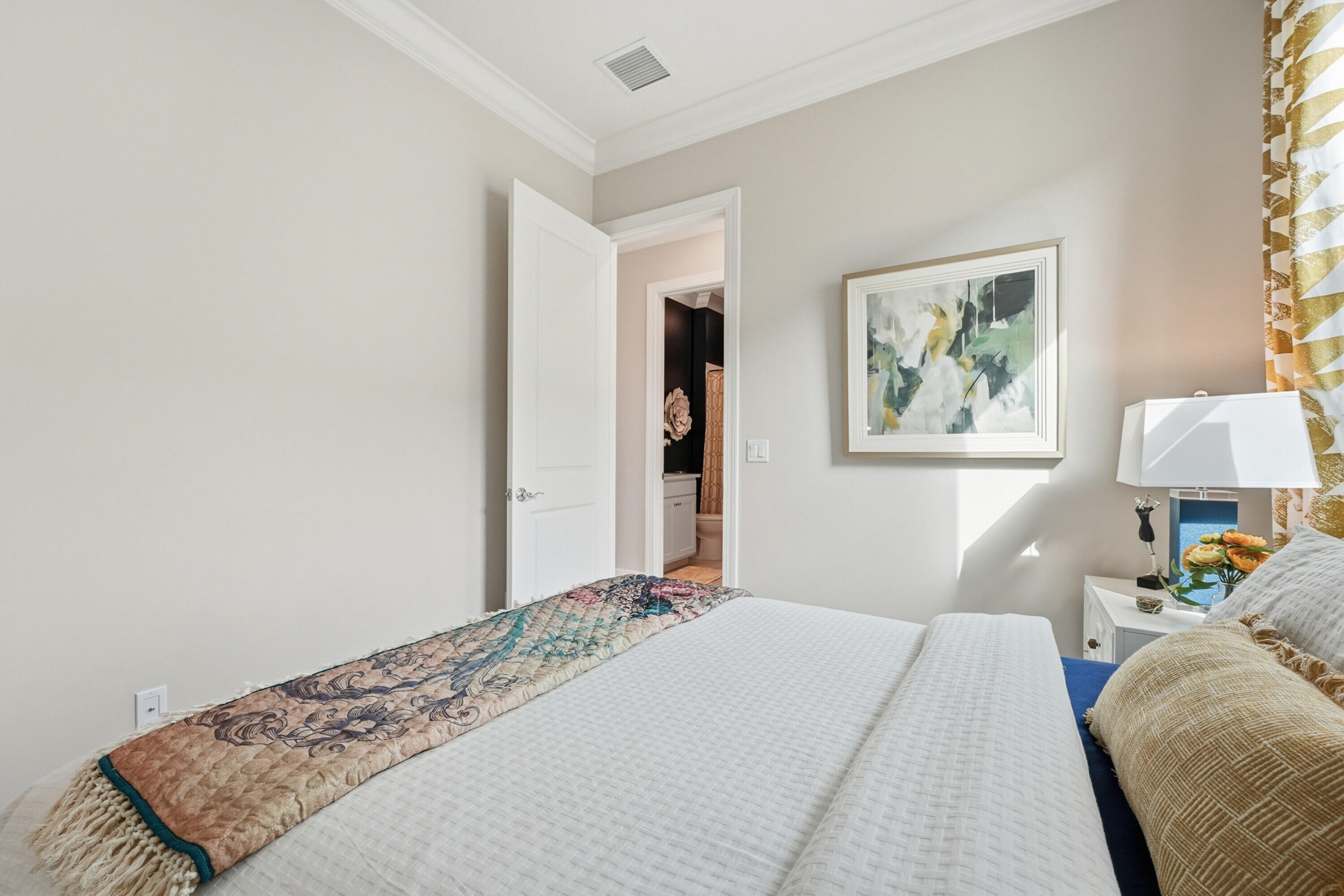 9321 Southwest Pepoli Way Port St. Lucie, FL 34987 - Photo 18 of 65 a bedroom with a bed and a lamp on dresser