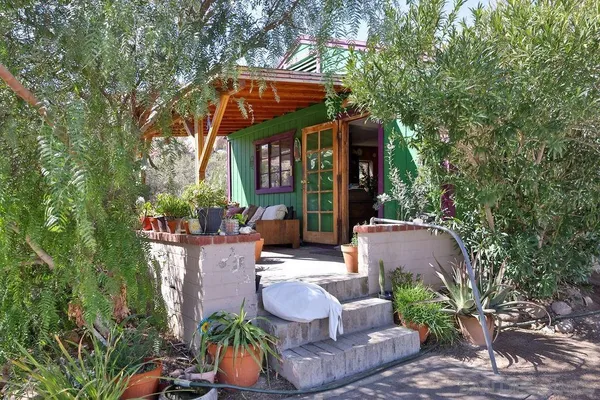 a patio with table and chairs and potted plants