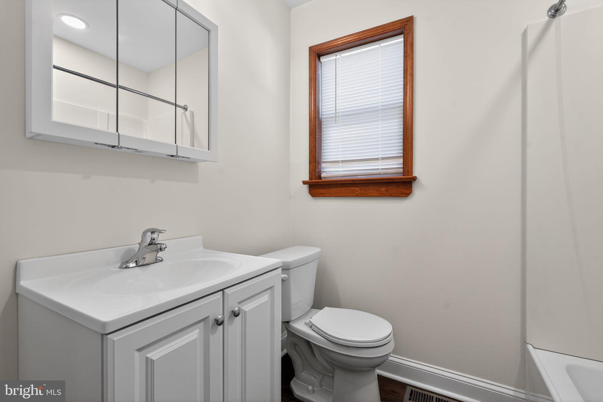 511 3rd Avenue Audubon, NJ 08106 - Photo 13 of 23 a bathroom with a sink a toilet and mirror