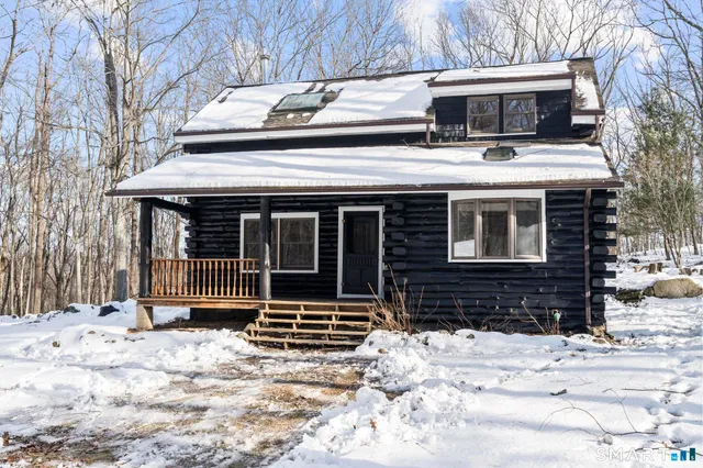 a front view of a house with a yard covered in snow