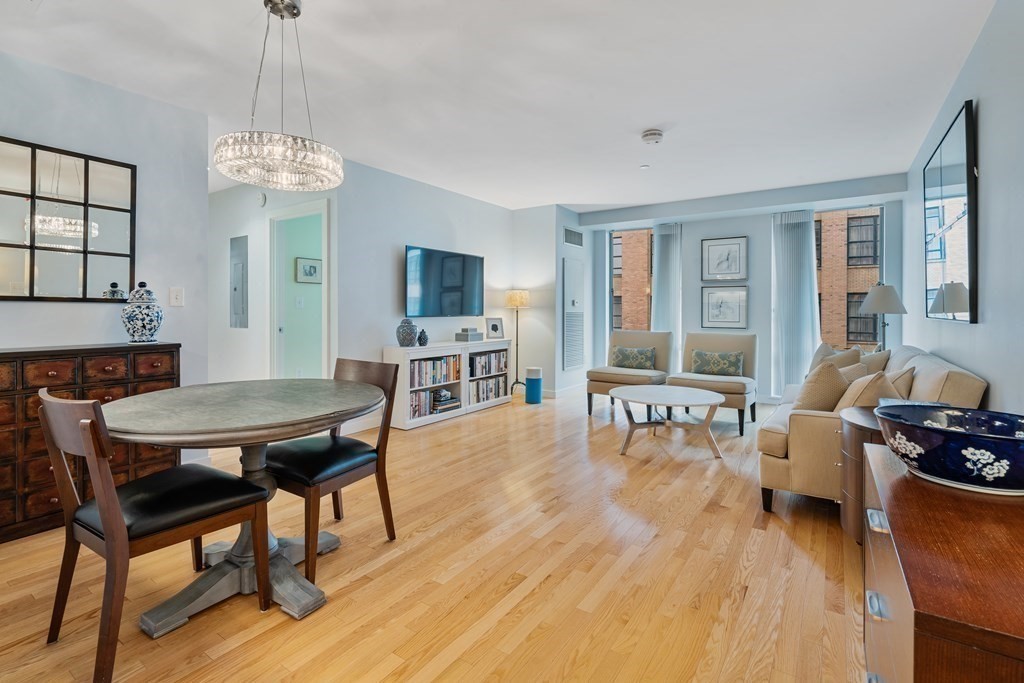 80 Broad Street, Unit 1002 Boston, MA 02110 - Photo 1 of 16 a living room with furniture and a wooden floor