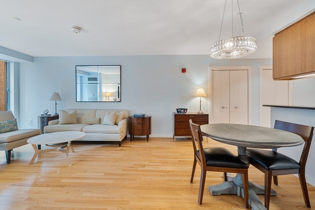 80 Broad Street, Unit 1002 Boston, MA 02110 - Photo 5 of 16 a living room with furniture and a chandelier