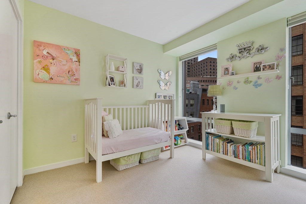 80 Broad Street, Unit 1002 Boston, MA 02110 - Photo 10 of 16 a bedroom with furniture and a book shelf