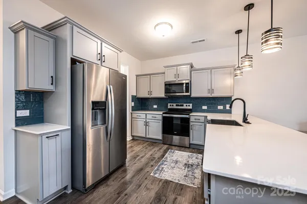 a kitchen with stainless steel appliances a refrigerator sink and microwave