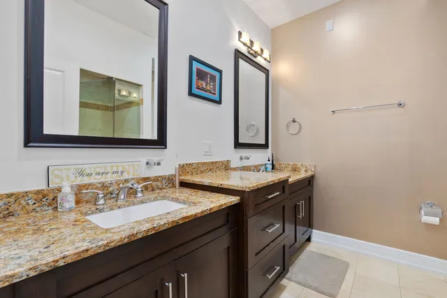 a bathroom with a granite countertop sink and a mirror