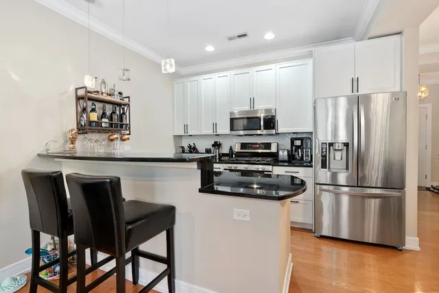 a kitchen with kitchen island a refrigerator stove and microwave