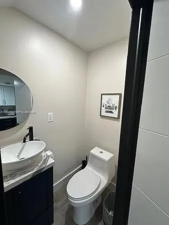 a bathroom with a toilet a sink and mirror