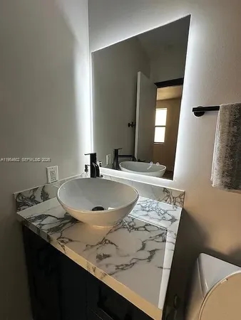 a bathroom with a granite countertop sink a mirror and bathtub