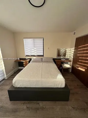 a large bed sitting in a bedroom next to a window