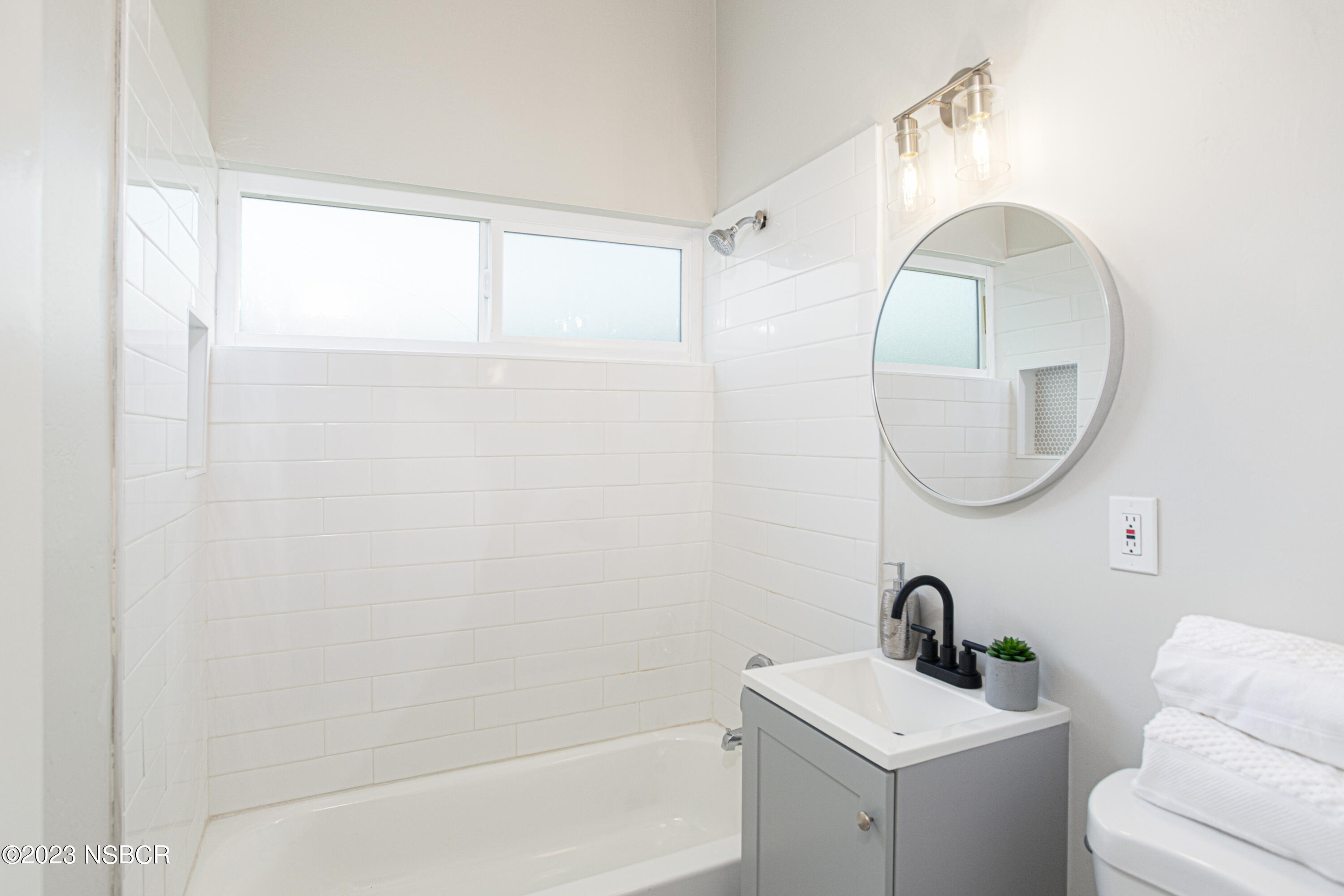 303 North Third Street Lompoc, CA 93436 - Photo 25 of 31 a bathroom with a sink a mirror and a shower