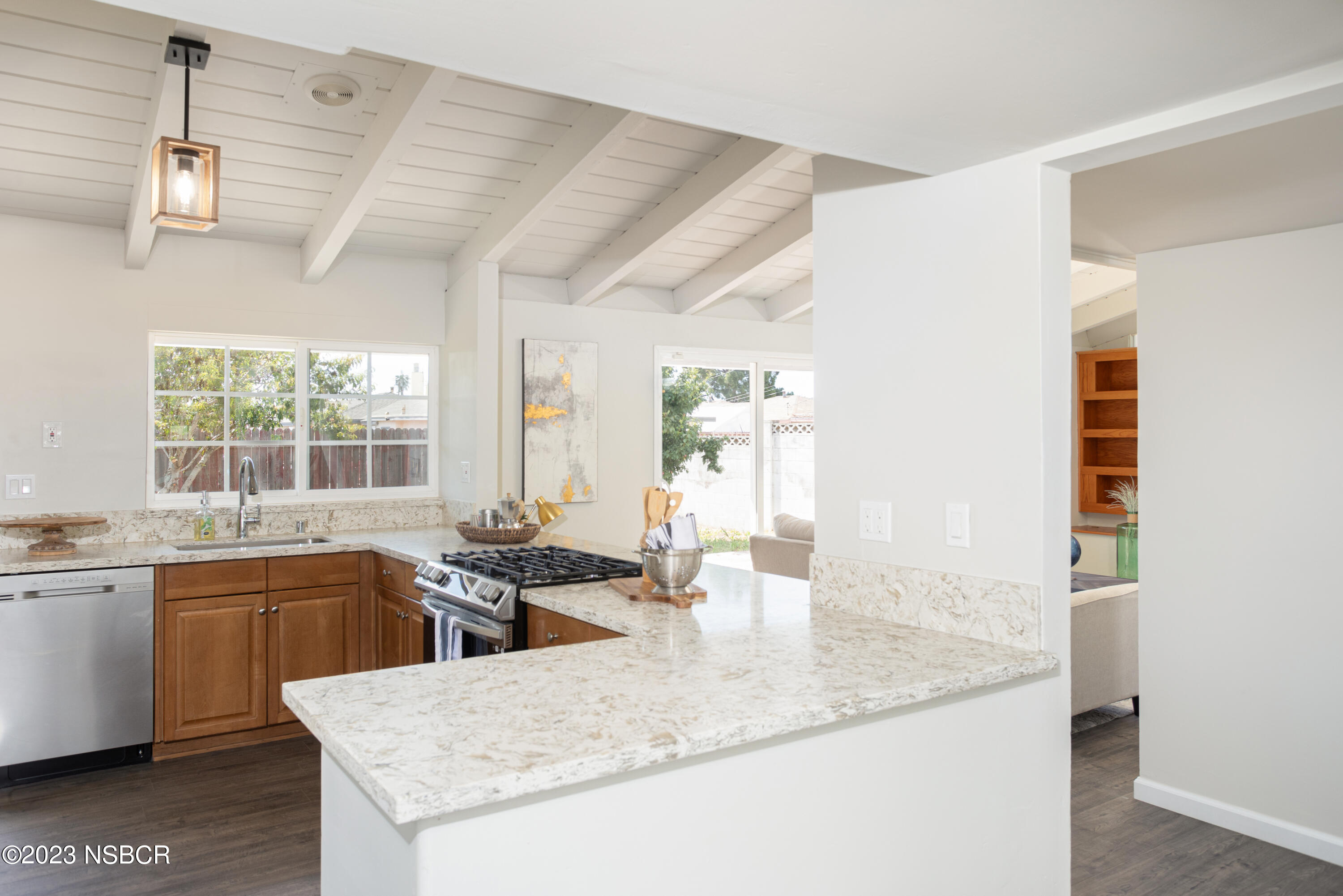 303 North Third Street Lompoc, CA 93436 - Photo 8 of 31 a kitchen with granite countertop a sink and white cabinets