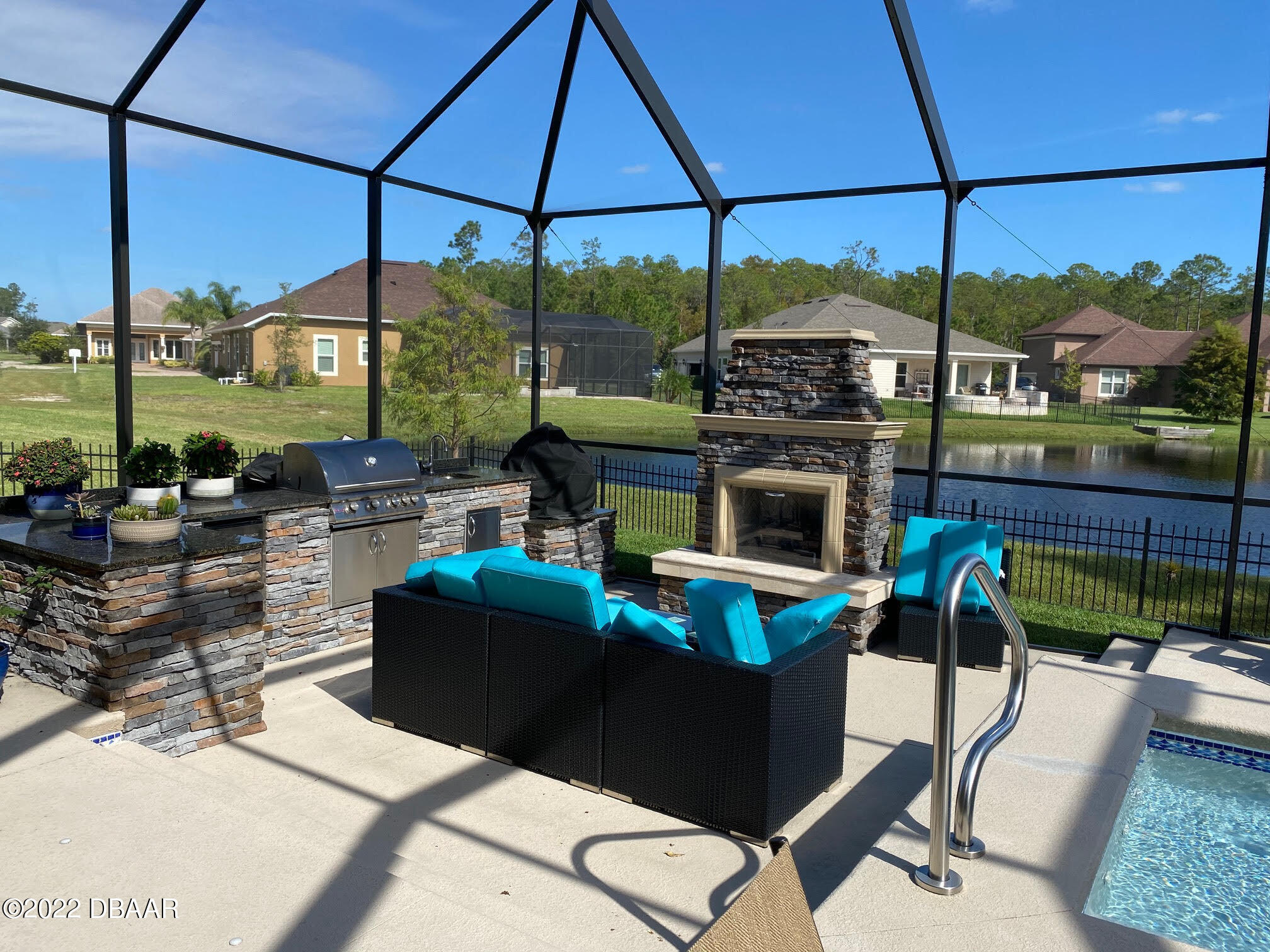 26 Ashford Lakes Drive Ormond Beach, FL 32174 - Photo 22 of 25 a living room with furniture a fireplace and floor to ceiling windows