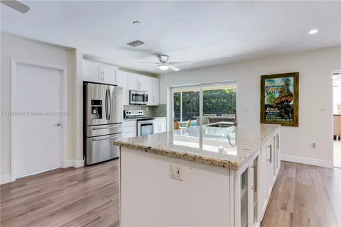 a kitchen with granite countertop a refrigerator and a sink