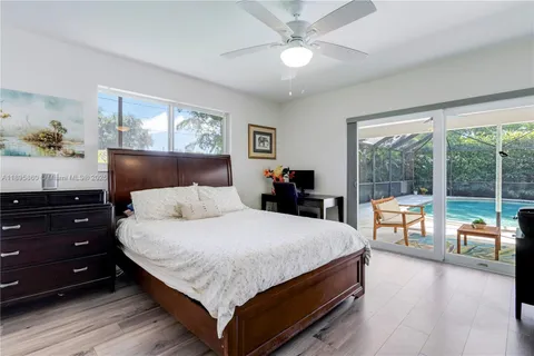 a bedroom with a large bed and a chandelier fan