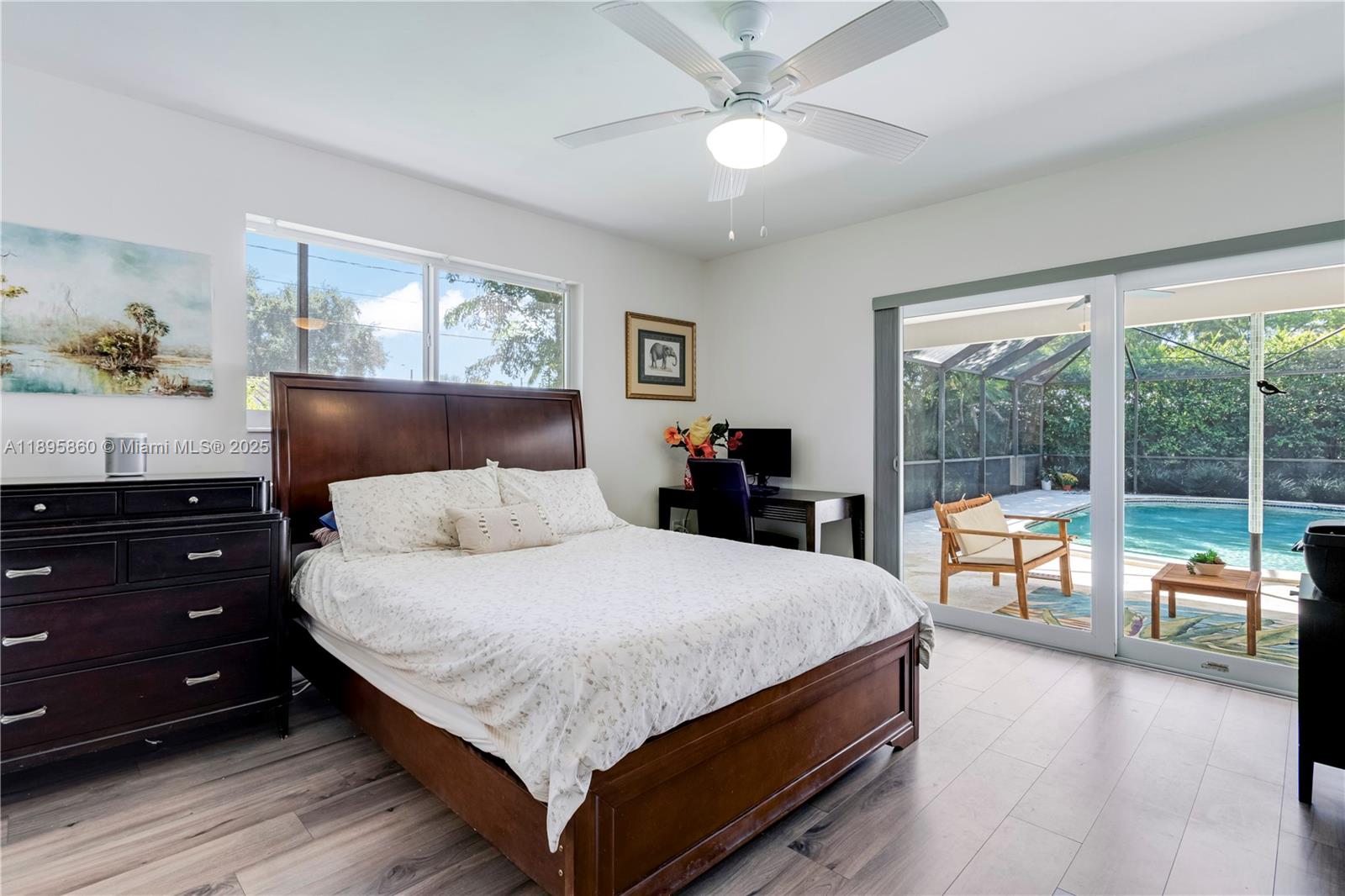 13905 Southwest 78th Court Palmetto Bay, FL 33158 - Photo 13 of 32 a bedroom with a large bed and a chandelier fan