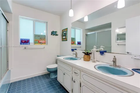 a bathroom with a granite countertop sink mirror vanity and toilet