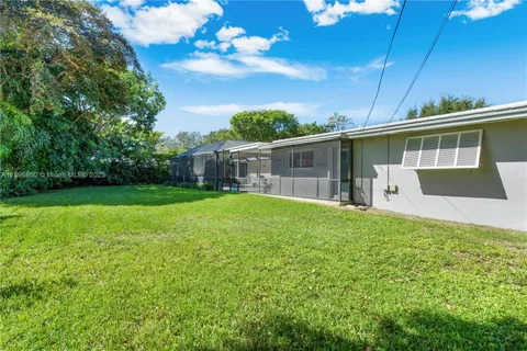 a view of a house with backyard and sitting area