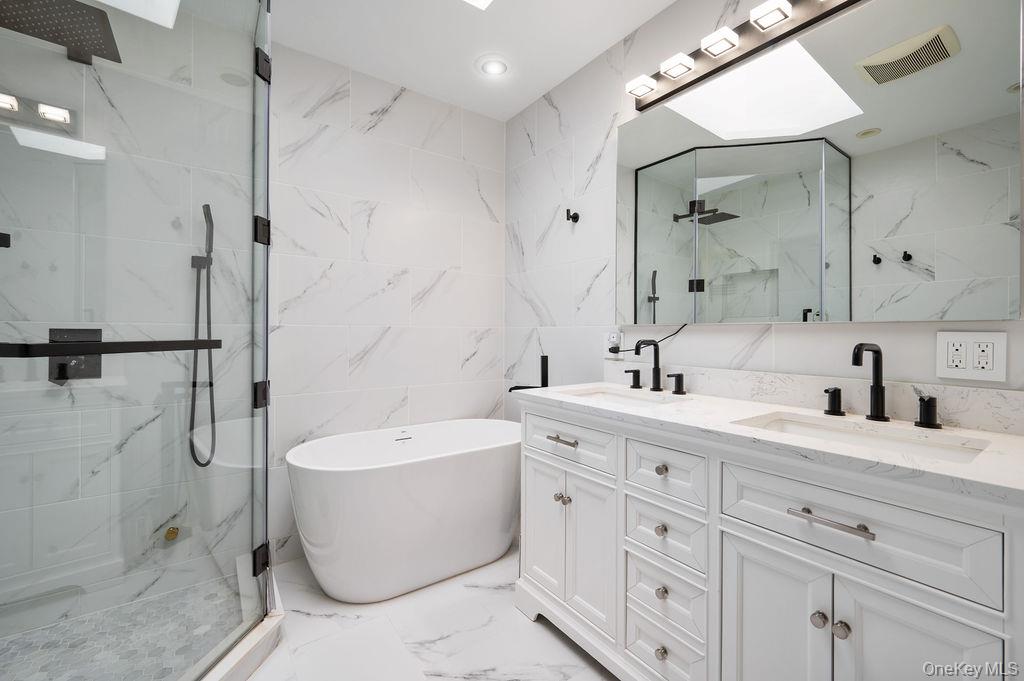 22 Crane Road Scarsdale, NY 10583 - Photo 14 of 32 Primary bathroom with a double vanity, soaking tub, radiant floors and a skylight.