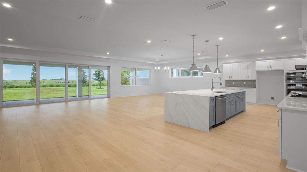 1615 Bellagio Loop Tavares, FL 32778 - Photo 3 of 39 a large white kitchen with a large window a sink and a counter top space