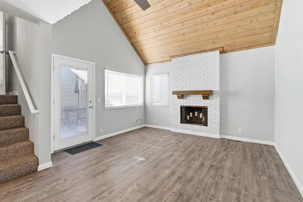 an empty room with wooden floor and fireplace