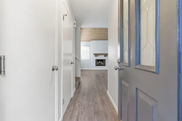 a view of a hallway with wooden floor and staircase