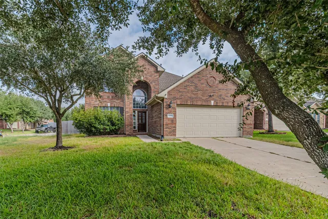 a front view of a house with a yard and tree