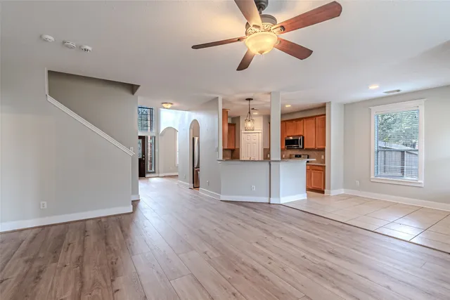 a view of a kitchen with a dishwasher cabinets wooden floor and a ceiling fan