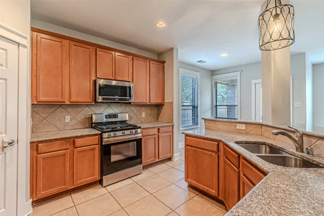 a kitchen with granite countertop a stove top oven sink and cabinets