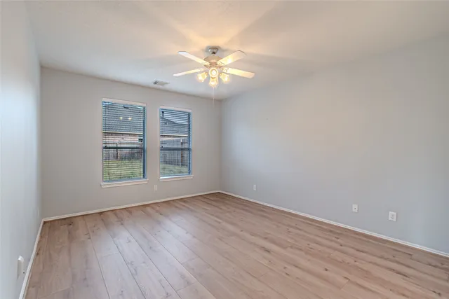 a view of an empty room with a chandelier fan