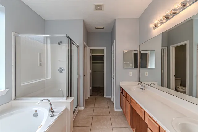 a spacious bathroom with a tub sink and mirror