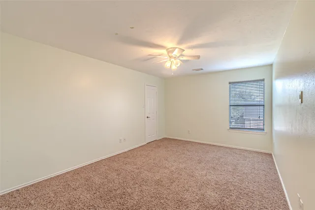 a view of an empty room with a chandelier fan