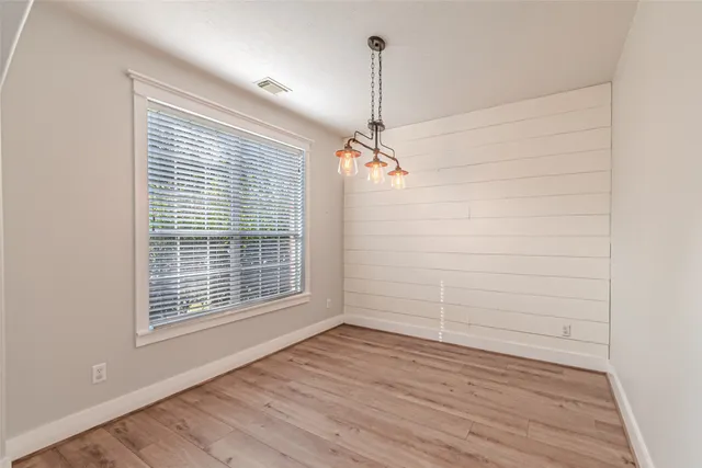 a view of a livingroom with a fireplace a ceiling fan and windows
