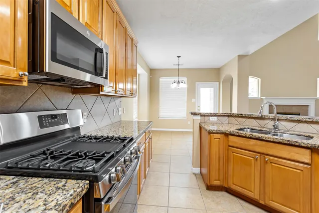 a kitchen with kitchen island granite countertop a sink stove and cabinets