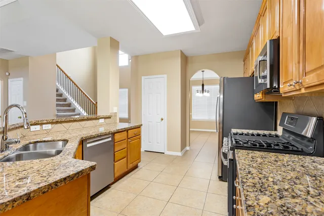a kitchen with stainless steel appliances granite countertop a sink stove and refrigerator