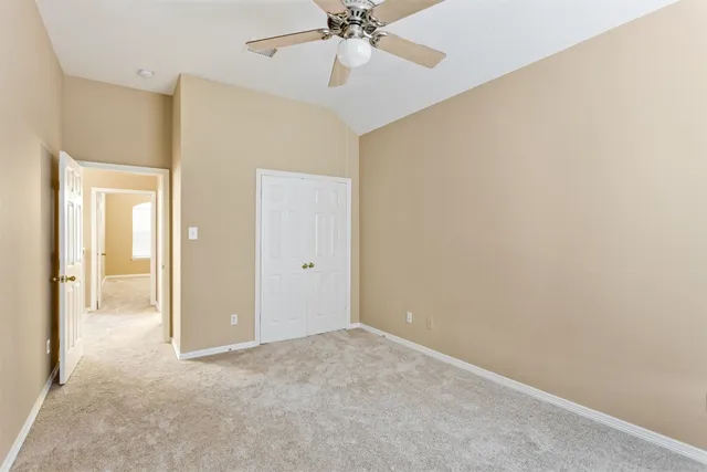 an empty room with fan and entrance