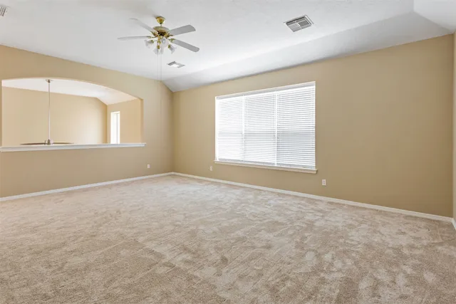 an empty room with a window and a ceiling fan