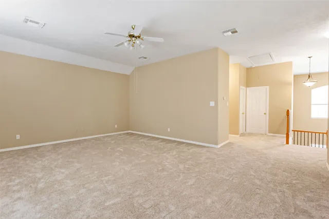 an empty room with a ceiling fan and a window
