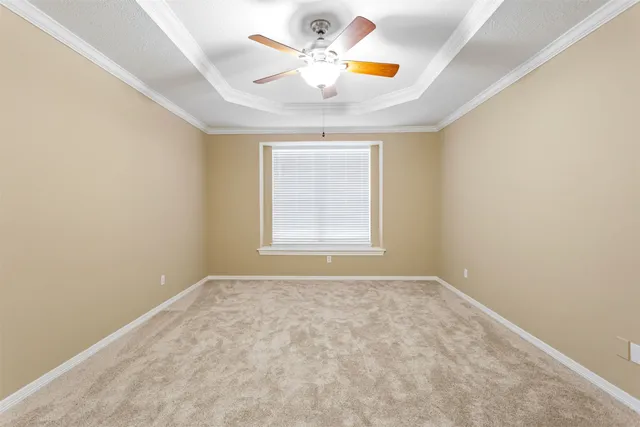 an empty room with window and ceiling fan
