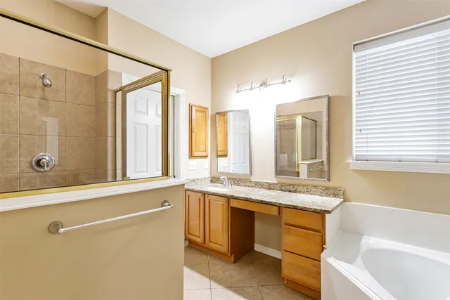 a bathroom with a granite countertop sink mirror bathtub and shower