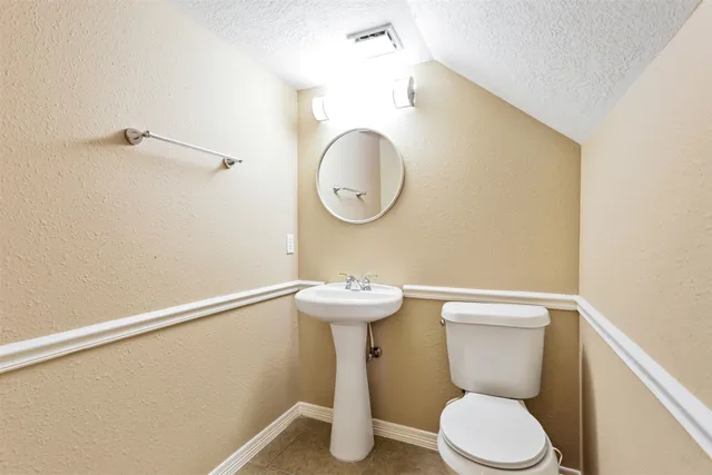 a bathroom with a toilet a sink and a mirror