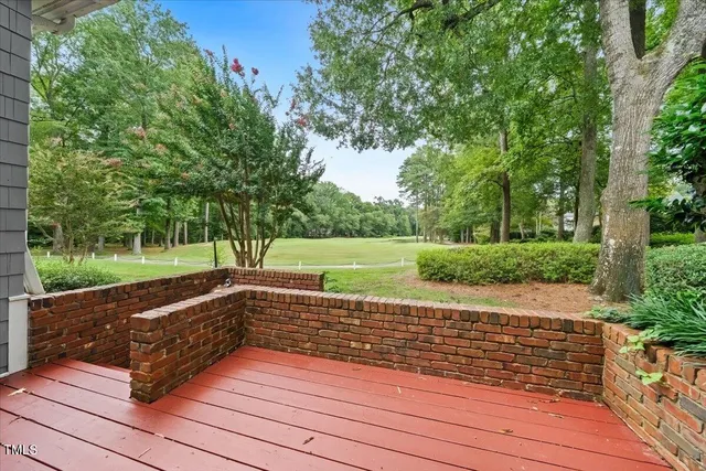 a view of a yard with wooden floor and large trees