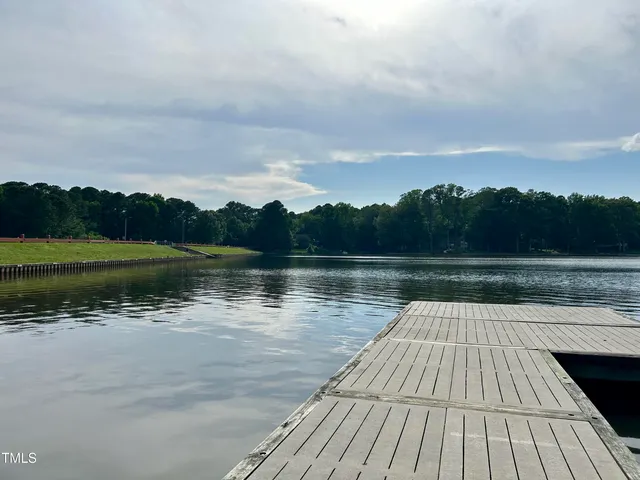 a area with lots of table and chairs under an umbrella