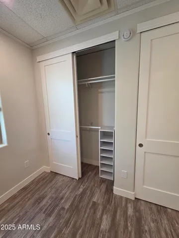 a view of walk in closet with wooden floor