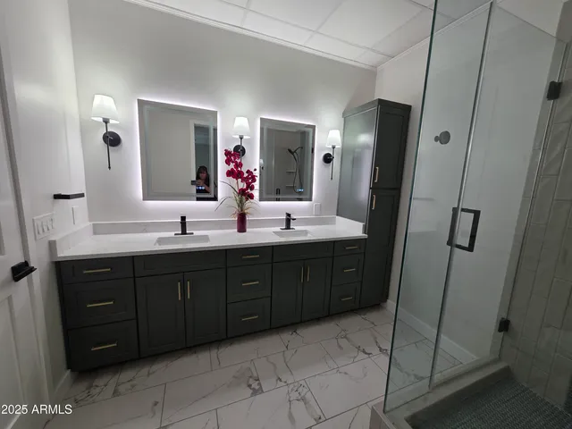 a spacious bathroom with a double vanity sink a mirror and a bathtub